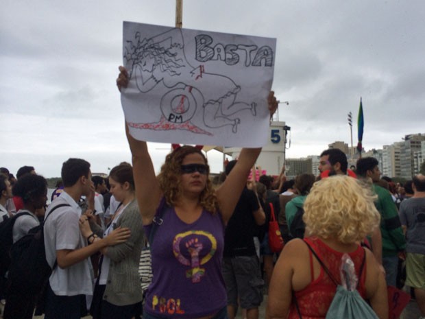 Mulher levanta cartaz que remete ao estupro de PMs (Foto: Lívia Torres / G1)