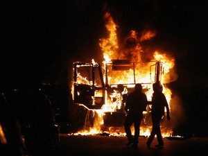 Egípcios observam veículo policial incendiado, após confrontos entre manifestantes e as forças de segurança (Foto: Mohammed Shokry/AP)