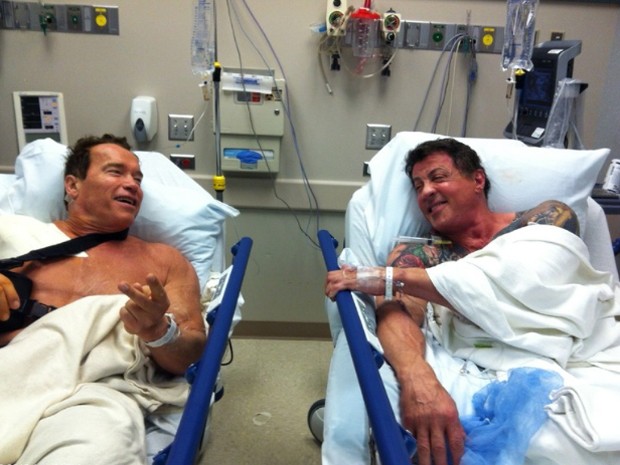 Schwarzenegger publicou em seu Twitter foto ao lado de Stallone em hospital. "Depois de toda a ação, acrobacias e abuso físico em 'Os mercenários 2', era hora de tratar o ombro. Olha quem estava coincidentemente na fila atrás de mim para sua cirurgia no o (Foto: Divulgação)