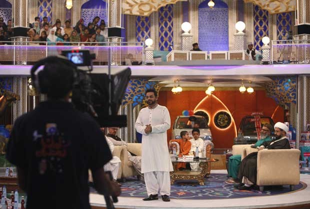 Aamir Liaquat Hussain apresentando o programa 'Amaan Ramazan', que está distribuindo bebês no Paquistão (Foto: Akhtar Soomro/ Reuters )