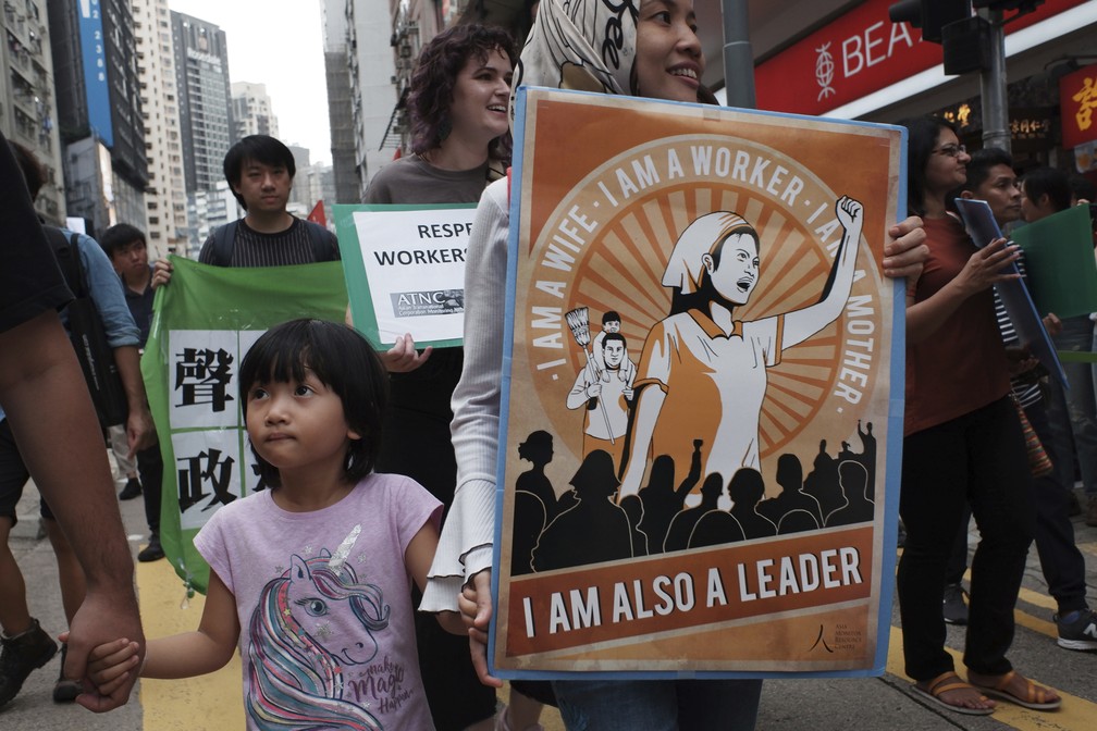 Manifestantes marcham para marcar o 1º de maio em Hong Kong. Trabalhadores da construção civil, motoristas de ônibus, autônomos e trabalhadores domésticos das Filipinas e Indonésia participaram da marcha na cidade. — Foto: Kin Cheung/AP