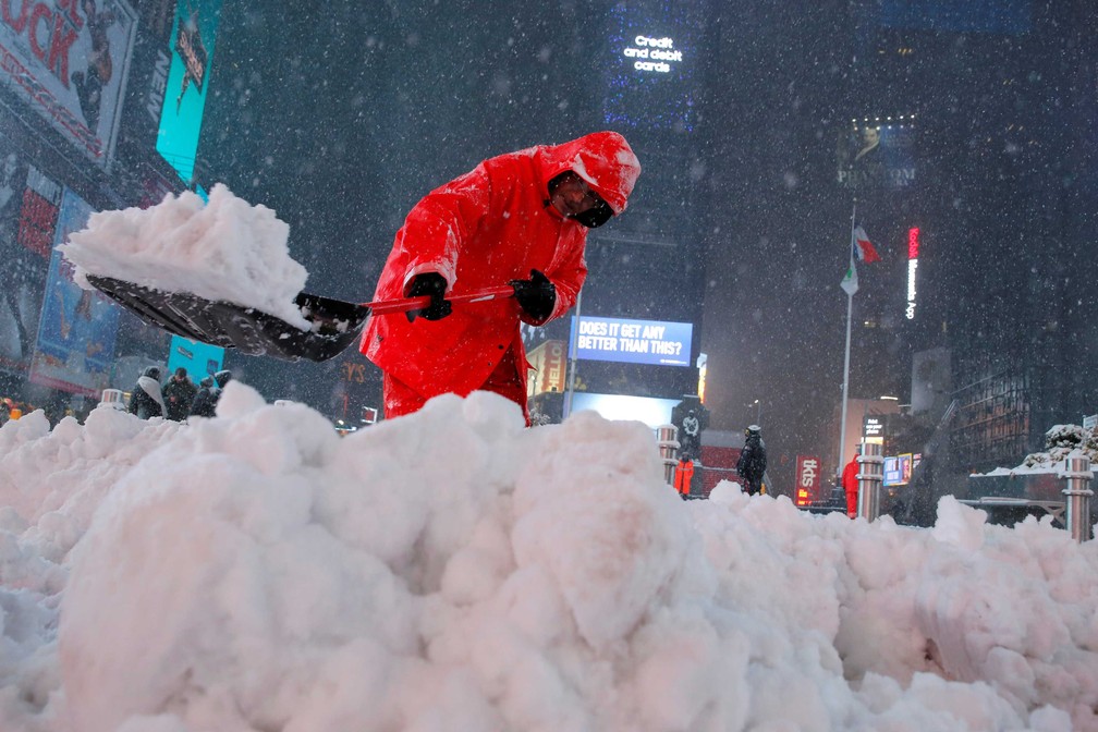 Trabalhador tira neve da Times Square após neve atingir a Manhattan, em Nova York, nesta terça-feira (14)  (Foto: Andrew Kelly/ Reuters)