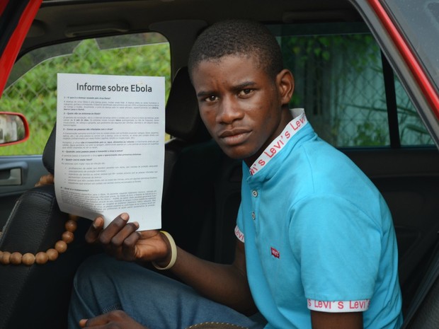 Imigrante haitiano recebe folheto com informações sobre ebola (Foto: Yuri Marcel/G1)