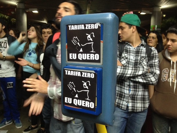 Manifestantes colam adesivos nas catracas a favor da tarifa zero (Foto: Cristiano Anunciação/G1)