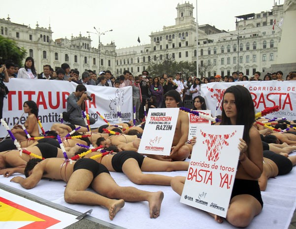 Vestidos apenas de shorts, manifestantes contra tourada fazem protesto em praça no centro de Lima (Foto: Enrique Castro-Mendivil/Reuters)