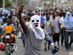 22/01 - Manifestantes marcham durante um protesto contra as eleições presidenciais em Porto Príncipe, no Haiti.  A autoridade eleitoral do país adiou o segundo turno das eleições que aconteceria neste domingo (24) após protestos e acusações de fraude (Foto: Hector Retamal/AFP)
