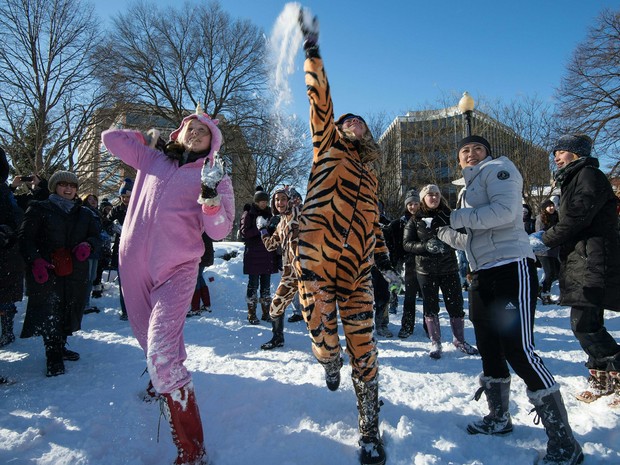  Pessoas participam de uma batalha de bolas de neve em Dupont Circle, em Washington D.C. neste domingo, depois de tempestade de neve  (Foto: AFP/Nicholas Kamm)