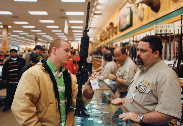 LIVRE PARA ATIRAR Um homem compra um rifle em promoção numa loja de armas no Estado do Texas. A posse de armas nos Estados Unidos é uma tradição presente na Constituição (Foto: Jessica Rinaldi / Reuters )