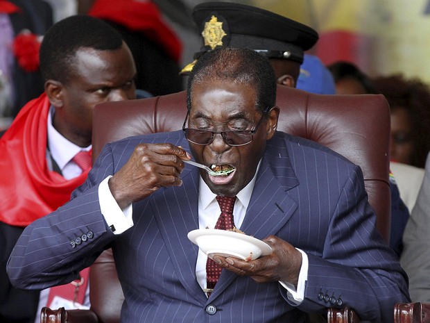 Robert Mugabe come bolo em sua festa de aniversário de 92 anos no Zimbábue (Foto: Philimon Bulawayo/AFP)