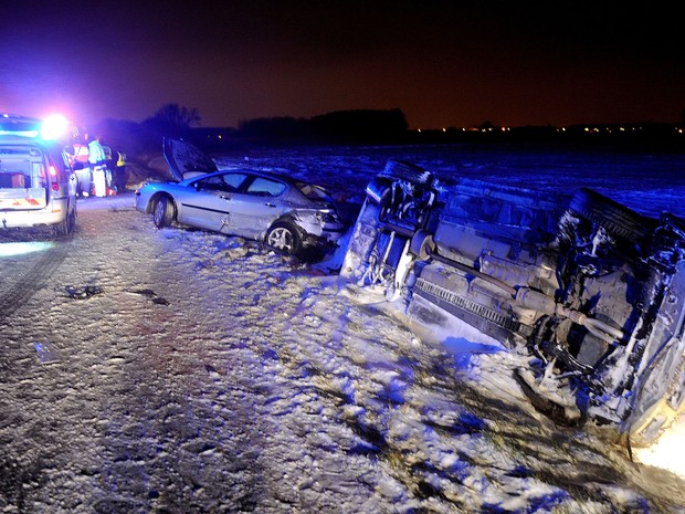 Polícia e bombeiros trabalham no local de um acidente envolvendo três carros em rodovia coberta de neve perto da cidade francesa de Lille. 14 pessoas foram feridas. (Foto: Denis Charlet/AFP)