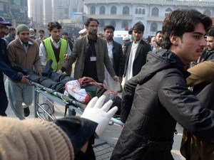 Estudante ferido em ataque de homens do Talibã armados a uma escola é levado a um hospital em Peshawar, no Paquistão. A escola é frequentada por filhos de militares paquistaneses (Foto: A Majeed/AFP)