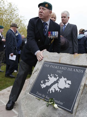 Veterano toca uma placa em homenagem aos mortos nos conflitos nas Malvinas, em Alrewas, neste domingo (20) (Foto: Reuters)