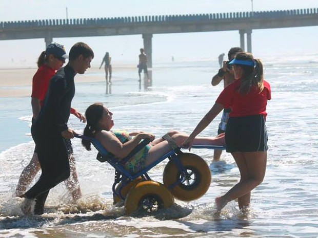 Cadeirantes tiveram acesso ao banho de mar com auxílio de cadeira (Foto: Almir Fernandes de Souza/Divulgação)