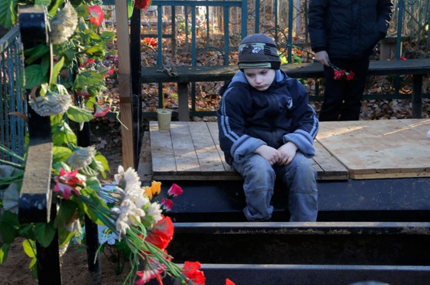 Mikhail, neto de Nina Lushchenko, uma das vítimas da queda do voo de um avião russo na península do Sinai, no funeral da avó (Foto: Ivan Sekretarev/AP) Mikhail, neto de Nina Lushchenko, uma das vítimas da queda do voo de um avião russo na península do Sinai, no funeral da avó (Foto: Ivan Sekretarev/AP)