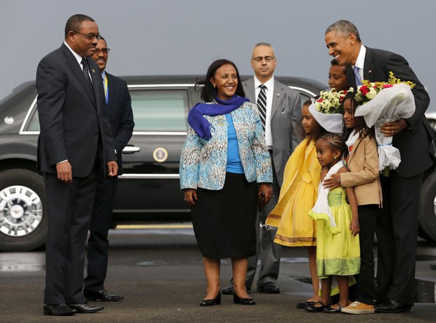 Obama recebe flores de crianças na chegada à Etiópia neste domingo (26); na foto, ele é observado pelo primeiro-ministro etíope Hailemariam Desalegn (esq.)  (Foto: Reuters/Jonathan Ernst)