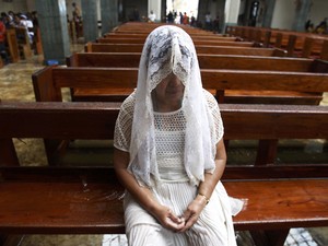 A fiel Anita Madirazo Villanueva reza na Igreja de Santo Niño, em Tacloban, nas Filipinas (Foto: Reuters/Edgar Su)