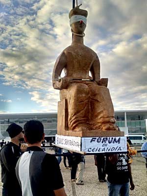 Manifestantes seguram maquete da estátua da Justiça com com nariz de palhaço durante protesto por reajuste (Foto: Isabella Formiga/G1)