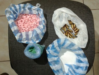 Dentro uma bolsa estavam os projéteis de 9mm, 214 gramas de cocaína, e cerca de 2 mil comprimidos, supostamente de ecstasy (Foto: Silvio Rogério/RPCTV Londrina)