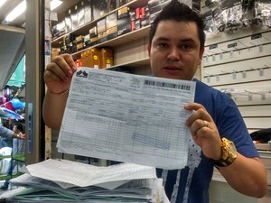  Lojista Ramilson Moraes mostra as notas fiscais dos produtos que vende (Foto: Gabriel Luiz/G1)