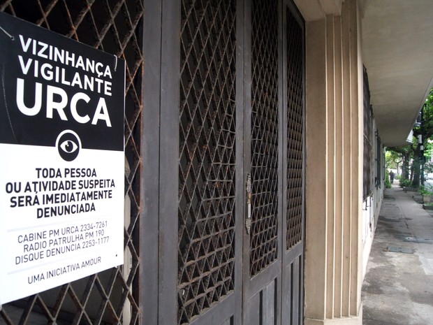 Cartaz afixado na portaria den um prédio na Rua Ramon Franco: segundo associação de moradores, objetivo é a prevenção de crimes (Foto: Henrique Porto/G1)