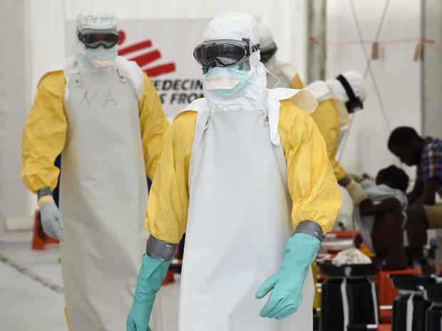  Profissionais da saúde, usando roupa protetora, trabalham em centro do Médicos sem Fronteiras em Monróvia, na Libéria, nesta sexta-feira (26)  (Foto: AFP Photo/Pascal Guyot)