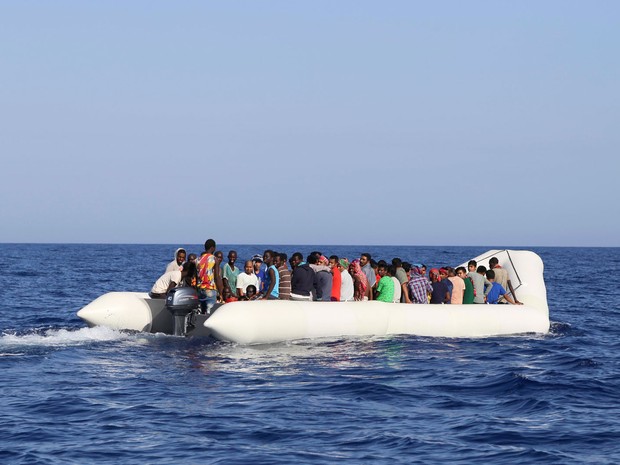 Migrantes são vistos em bote pouco antes de operação de resgate da ONG Migrant Offshore Aid Station na costa da Líbia, na quarta (14) (Foto: Stringer/AFP)
