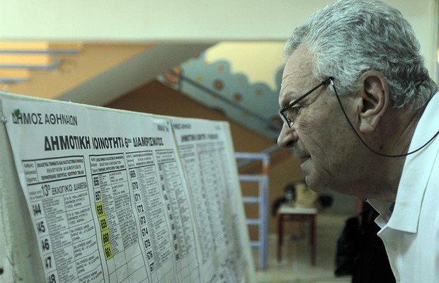 Homem grego checa sua sala de votação para responder a referendo (Foto: EFE)