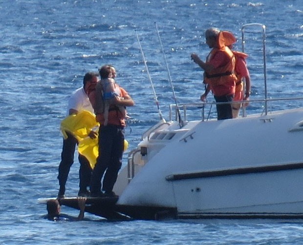Momento em que a criana  resgatada e trazida a bordo da lancha da Guarda Costeira (Foto: Hanife Erdinc/Anadolu Agency/AFP)
