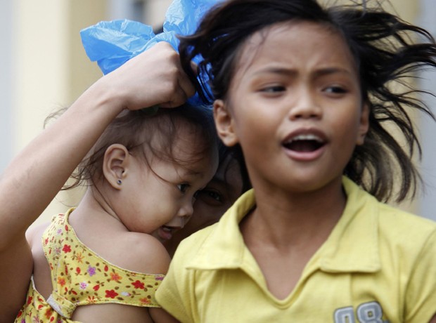 Crianças correm para abrigo na região costeira para se abrigar do tufão Hagupit, em Manila  (Foto: Reuters)