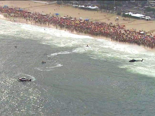 Equipes de socorro do Corpo de Bombeiros fazem as buscas ao helicóptero na Praia de Copacabana, neste sábado (29) (Foto: Reprodução/TV Globo)