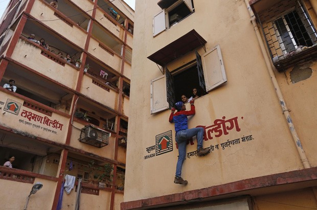 Candidato independente Gaurav Sharma é visto escalando prédios de eleitores em Mumbai, na Índia (Foto: Danish Siddiqui/Reuters)