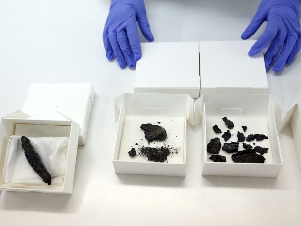 Lena Liebman, do laboratório de conservação dos pergaminhos do Mar Morto, mede um fragmento de pergaminho queimado na segunda (20), em laboratório em Jerusalém   (Foto: AFP Photo/Gali Tibbon)