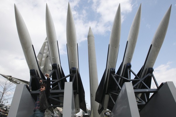 Sul-coreano faz pose em frente a imitações de mísseis Scud-B,  da Coreia do Norte Centro, e outros armamentos em exibição no Museu de Guerra de Seul, na Coreia do Sul (Foto: Ahn Young-joon/AP)
