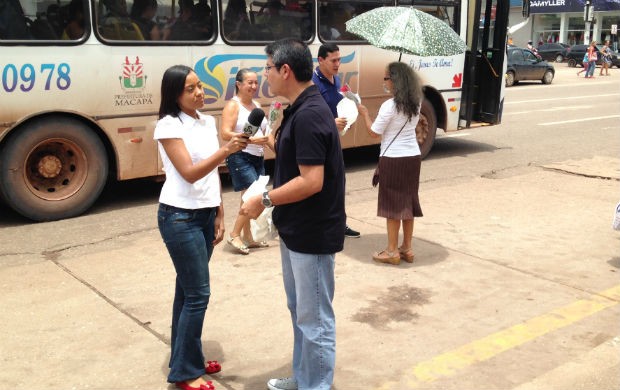 Repórter Carolina Xavier entrevistando o apresentador do Amapá TV Seles Nafes durante ação de entrega de flores no centro de Macapá (Foto: Celso Kato/TV Amapá)