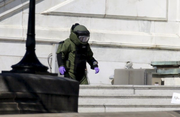 Um policial do esquadrão antibombas inspeciona um pacote suspeito no Capitólio, em Washington, nos EUA, após tiroteio nas imediações (Foto: Jim Bourg/Reuters) Um policial do esquadrão antibombas inspeciona um pacote suspeito no Capitólio, em Washington, nos EUA, após tiroteio nas imediações (Foto: Jim Bourg/Reuters)