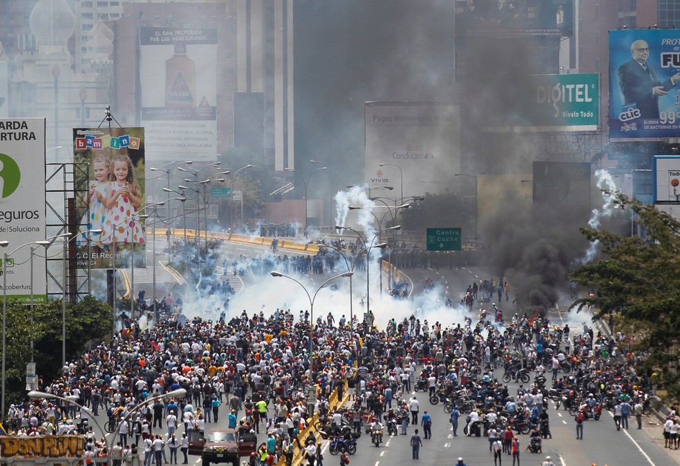 Manifestantes e policiais se enfrentam nesta segunda-feira (10) em Caracas (Foto: REUTERS/Christian Veron)