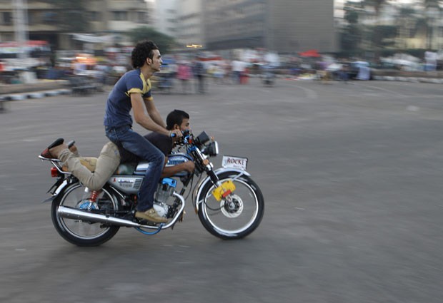 Dois egípcios foram flagrados andando em posição inusitada em moto (Foto: Amr Nabil/AP)