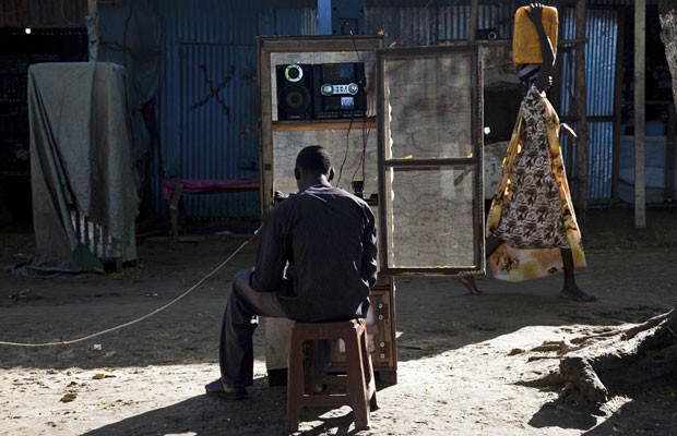 Em imagem tirada em junho deste ano, homem mexe em seu celular em um mercado de Pibor, no Sudão do Sul (Foto: Reuters)
