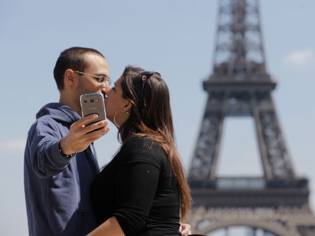 Casal faz selfie em frente à Torre Eiffel, em Paris (Foto: Christian Hartmann/Reuters)