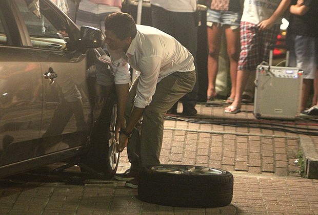 Rodrigo Lombardi troca pneu em gravação de "Salve Jorge" (Foto: Delson Silva/AgNews)