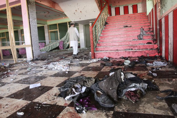 Afegão caminha no salão em que se comemoravam bodas após atentado neste sábado (14) (Foto: AFP)