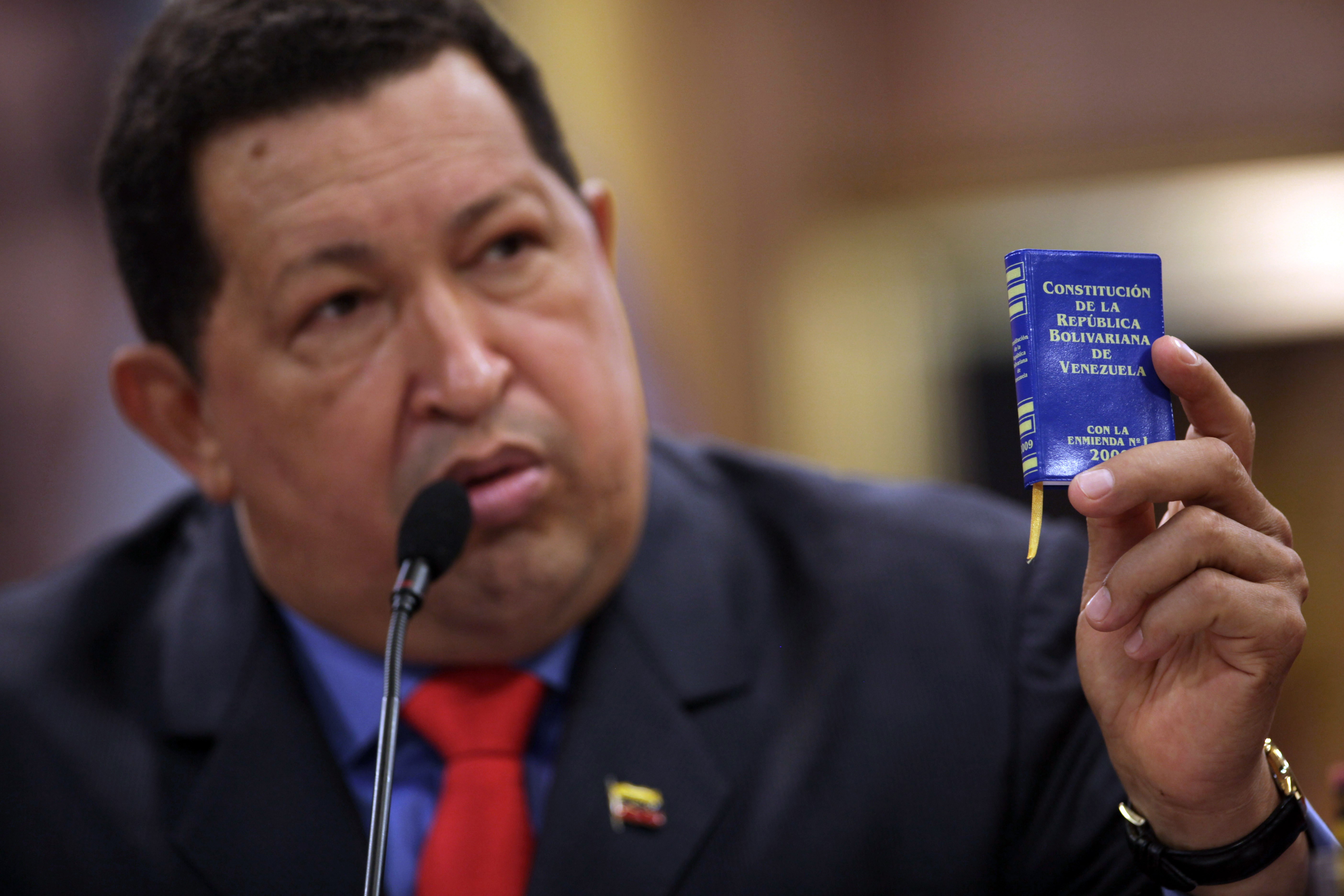 Em foto de 9 de outubro de 2012, o presidente da Venezuela, Hugo Chávez, fala em uma conferência segurando a ministura da constituição do país. (Foto: AP/ ASSOCIATED PRESS)