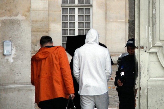 Benzema, com casaco branco, chega para depoimento na polícia em Paris (Foto: MATTHIEU ALEXANDRE / AFP)