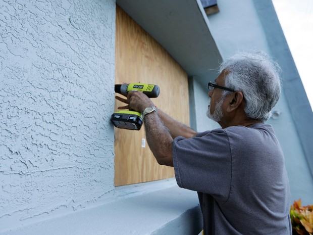Ray Gohill, dono do Sahara Motel, coloca proteção nas janelas de seu empredimento em Daytona Beach, na Flórida, com a chegada do furacão  (Foto: Chris O&#39;Meara/AP)