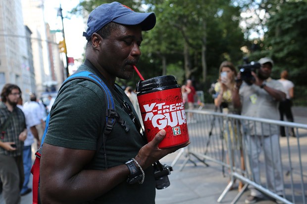 Manifestante toma refrigerante em copo gigante durante a Marcha do Grande Gole (Foto: Spencer Platt / Getty Images / AFP)