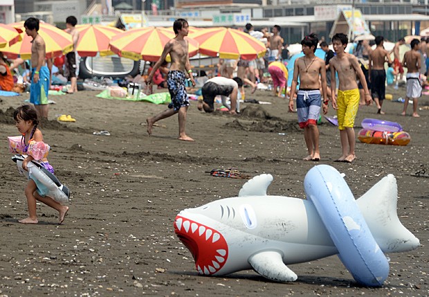 G Japoneses vão à praia neste sábado para suportar calor de mais de C notícias em Mundo