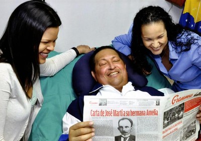 Imagem divulgada pelo governo da Venezuela mostra Hugo Chávez lendo um jornal ao lado das filhas (Foto: EFE)