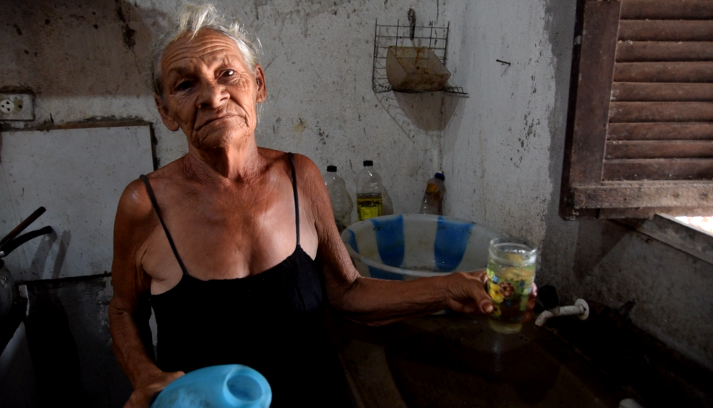 Francisca Ferreira depende de uma moradora do bairro que tem poço e revende água (Foto: Thyago Macedo / G1)