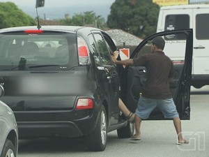 Assaltante tenta tirar passageira de dentro do carro  (Foto: Reprodução/G1)