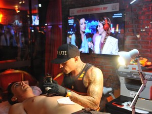 Di Ferrero fazendo tatuagem com Mariana Rios no telão (Foto: Bia Alves /AgNews)